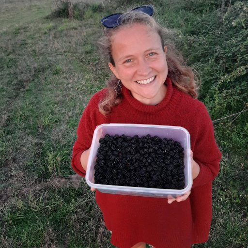 Dr Joanna Taylor holding fresh blackberries outdoors