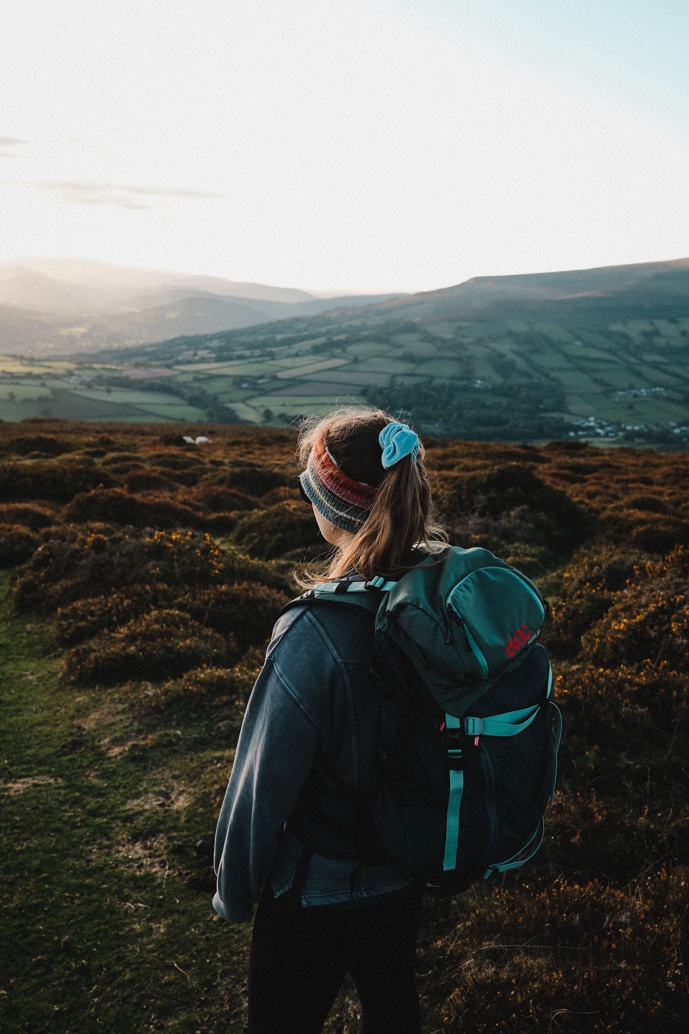 Dr Joanna Taylor walking in the countryside with a backpack, representing wellbeing and personal health journey