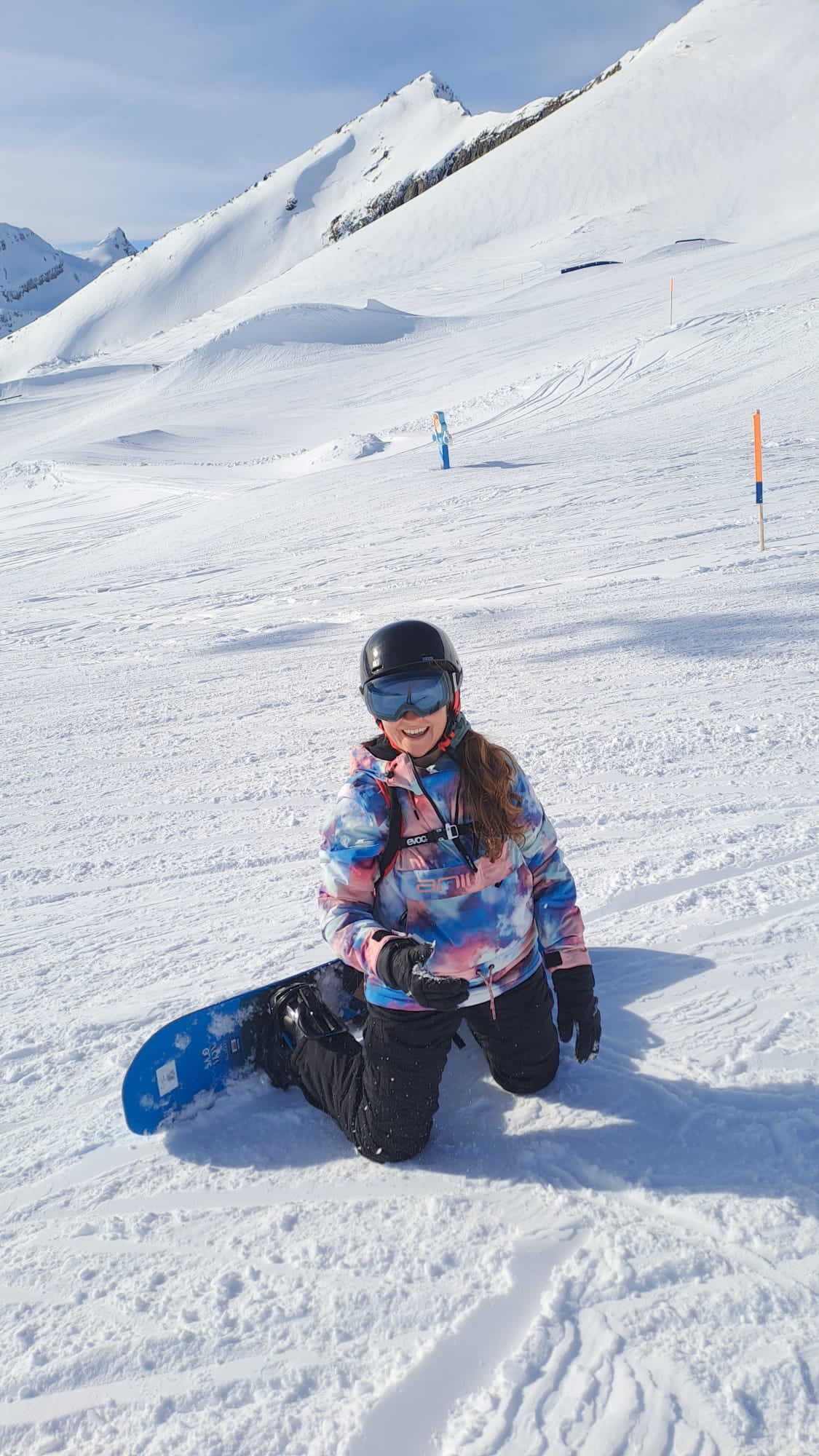 Dr Joanna Taylor snowboarding in the mountains, showing an active and adventurous lifestyle