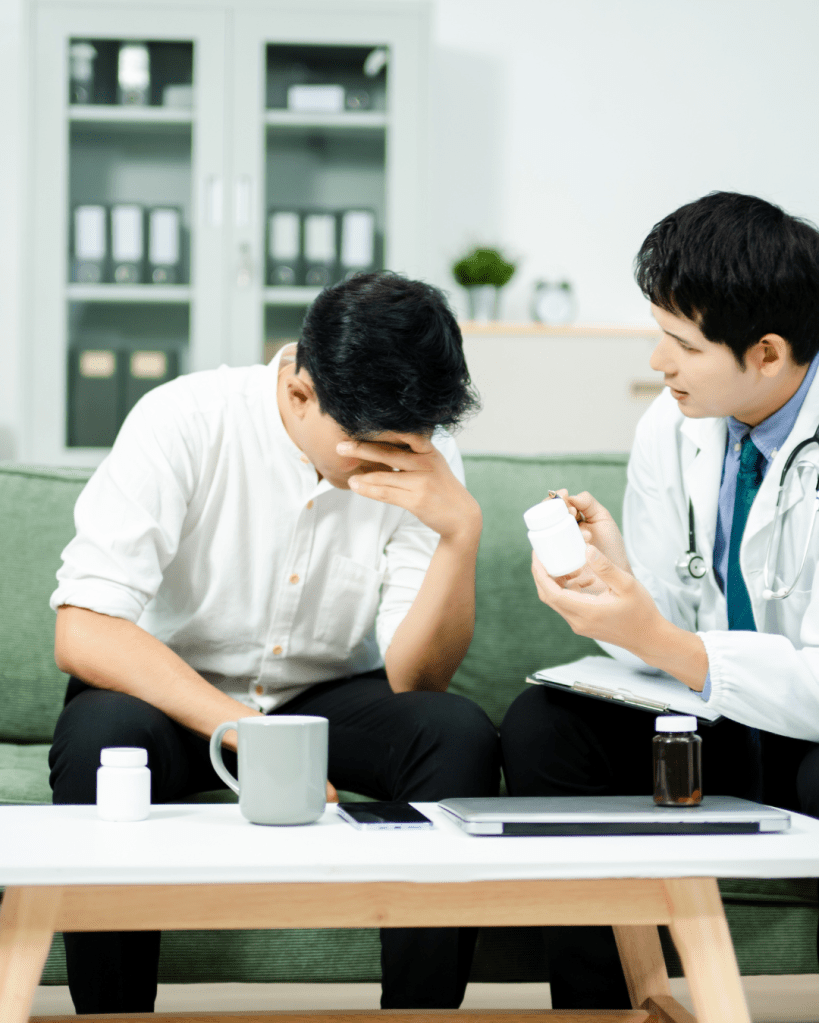 A doctor discussing medication with a patient who appears distressed, sitting in a modern office environment.