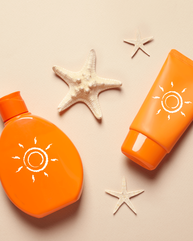 Two orange sunblock bottles and a starfish on a beige surface.
