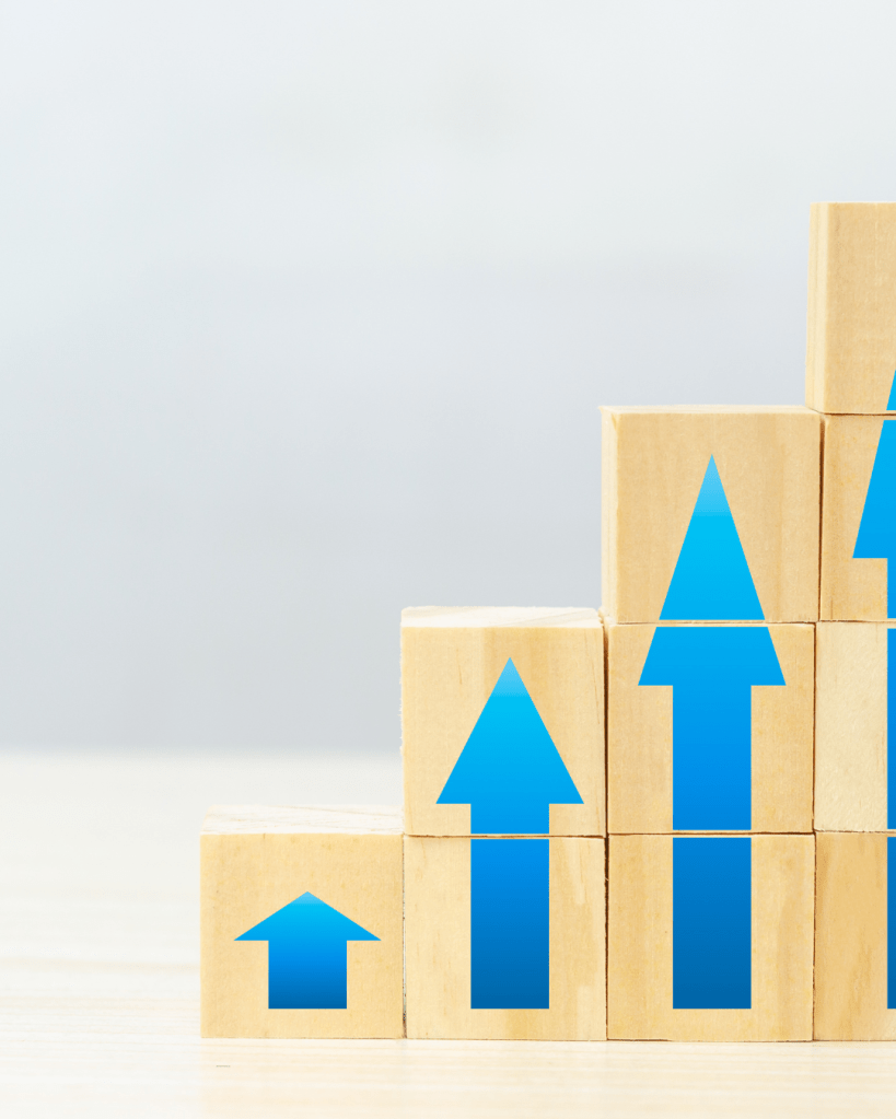 A stack of wooden blocks arranged in a stair-step pattern, each featuring blue upward arrows.